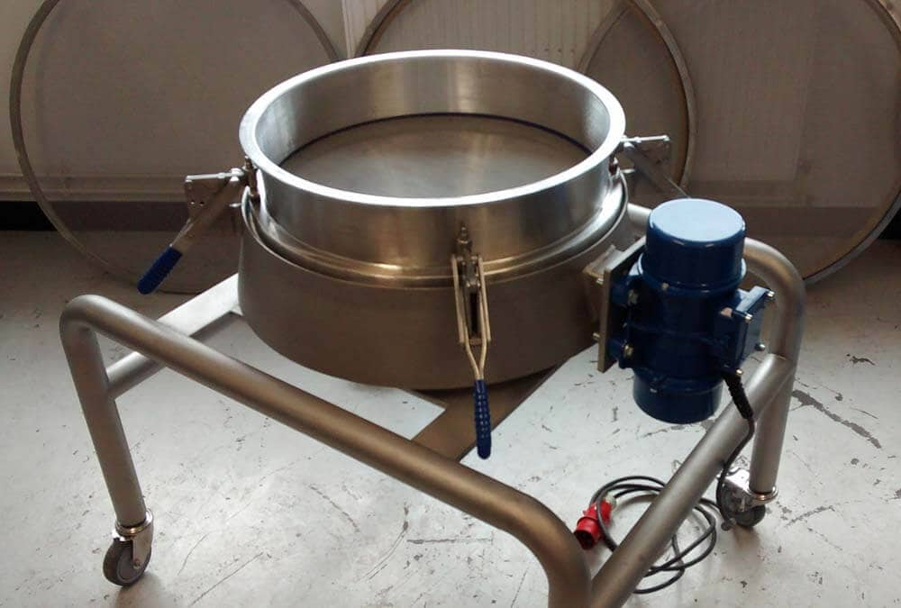 Vibrating batch sieve on mobile stand.